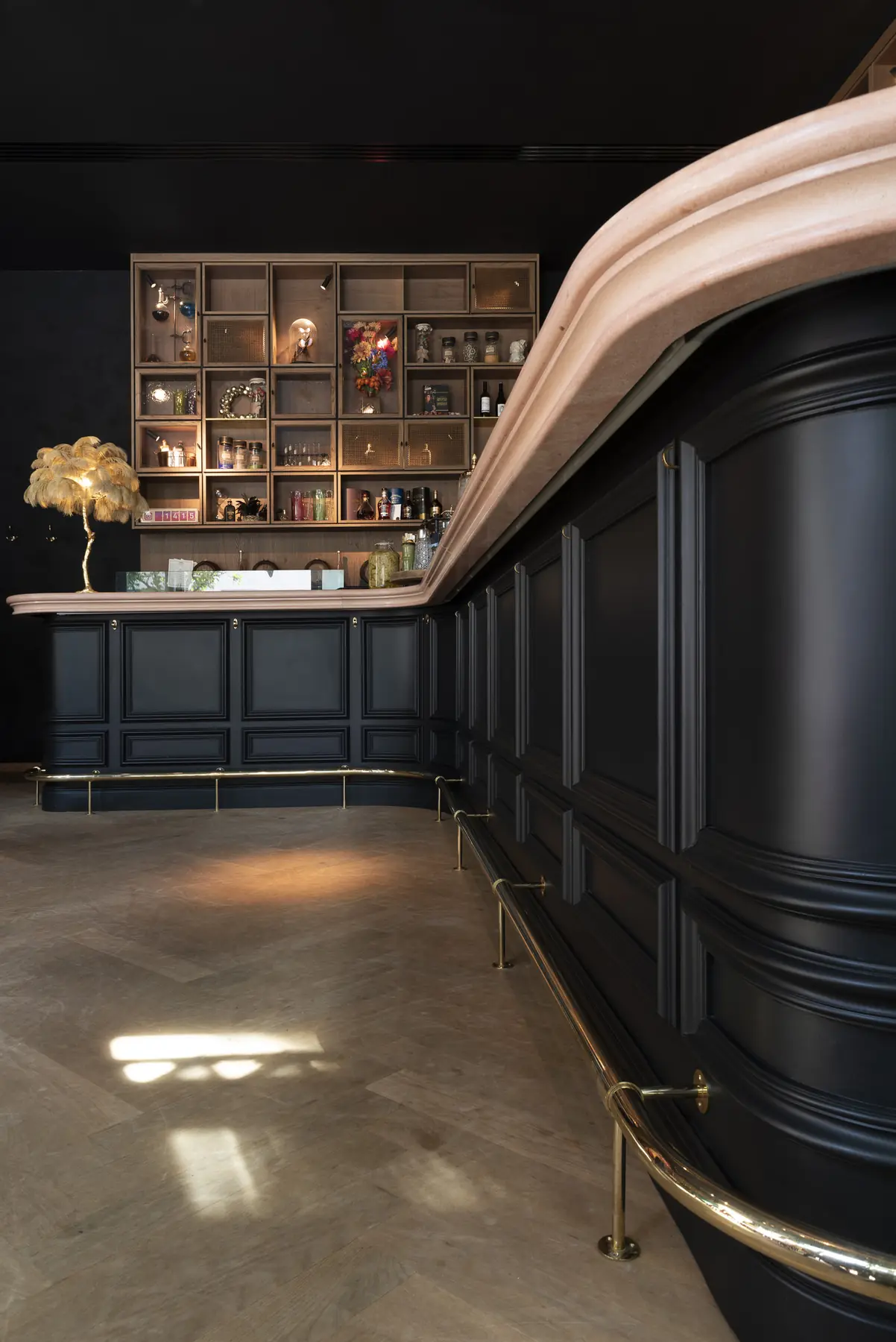Elegante dunkle Bar mit geschwungener Theke und Messingdetails