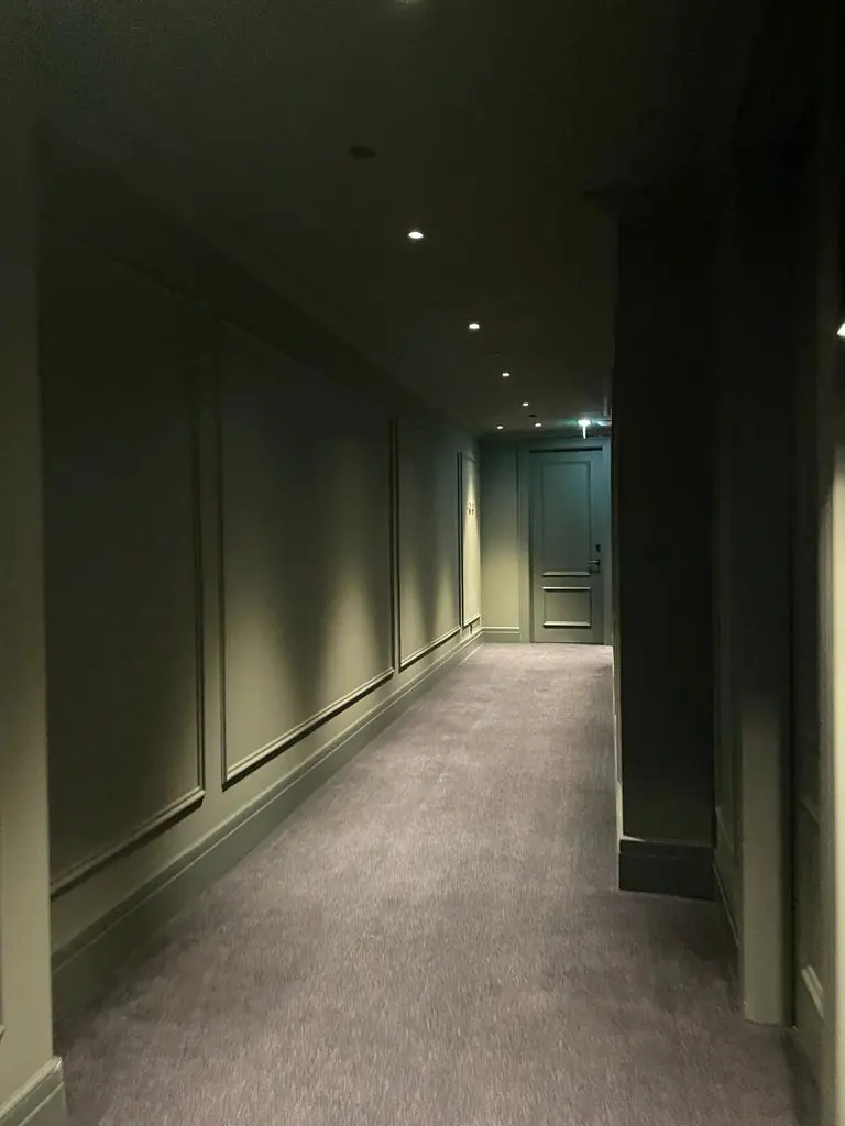 Dunkler Hotelflur mit klassischen Wandprofilen