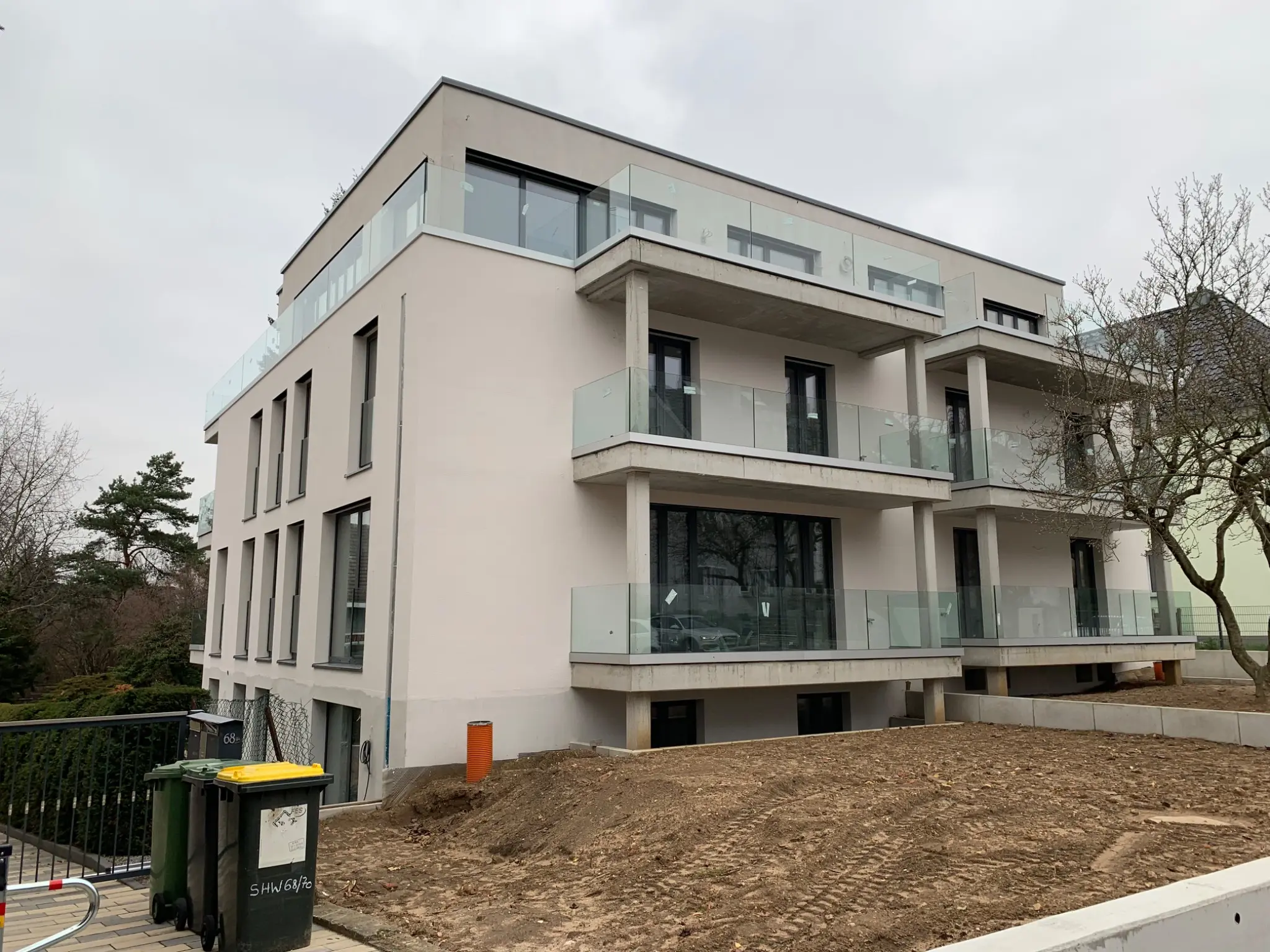 Moderner Neubau mit Glasbrüstungen während der abschließenden Außenarbeiten