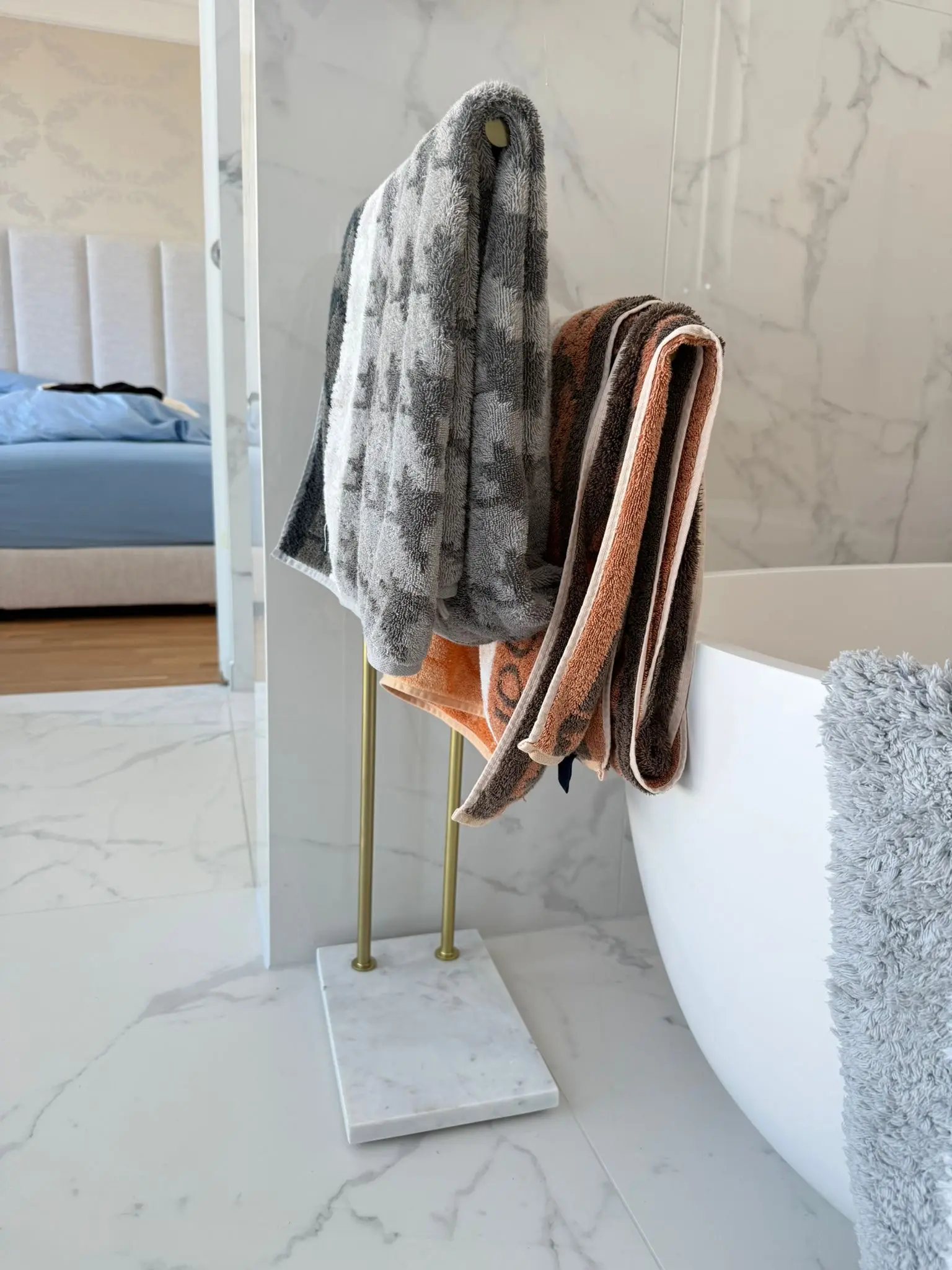 Badinnenausbau mit Natursteinoptik, freistehender Wanne und Messingdetails